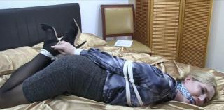 Damsel Delivery Ariel Anderssen is hogtied on the bed.