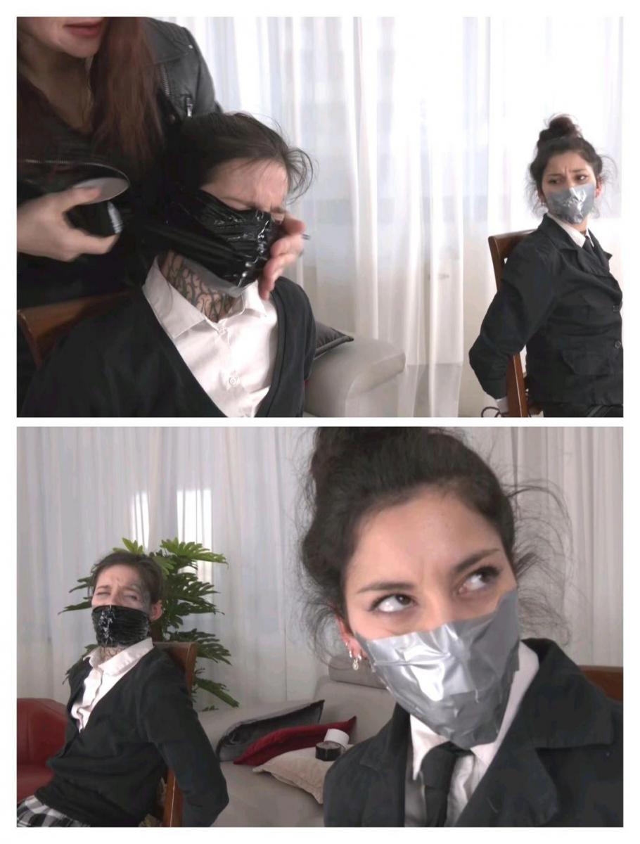 Tapegagged for the project Mayla and Numa are two colleagues and friends, both have noticed that their colleague Ammalia has created a really well-structured project that will most likely guarantee her a promotion and for this reason they are jealous. They decide to take possession of it by trying to obtain it by treat: they tie Ammalia to a chair and cover her mouth with duct tape and then start looking for the project files for the various rooms of the office. Ammalia, left alone, manages to free herself and waits for their return to take revenge. Luckily for her, the unwary ones don't return to her together, but Numa is the first to return and so Ammalia surprises her, gets the upper hand and ties her up exactly as was done to her: she puts a sock in her mouth and covers her lips well with generous turns of dutch tape. Numa gets scared and tries to scream but only incomprehensible sounds come out of her mouth. When Mayla arrives and sees her friend, she doesn't have time to react because Ammalia surprises her too and gives her the same treatment. The two accomplices now find themselves tied up and with their mouth taped shut. Ammalia makes fun of them, takes selfies to laugh at them and then leaves them like that, alone and tied up in the office. The girls are desperate and try in every way to free themselves, their plan was a disaster!