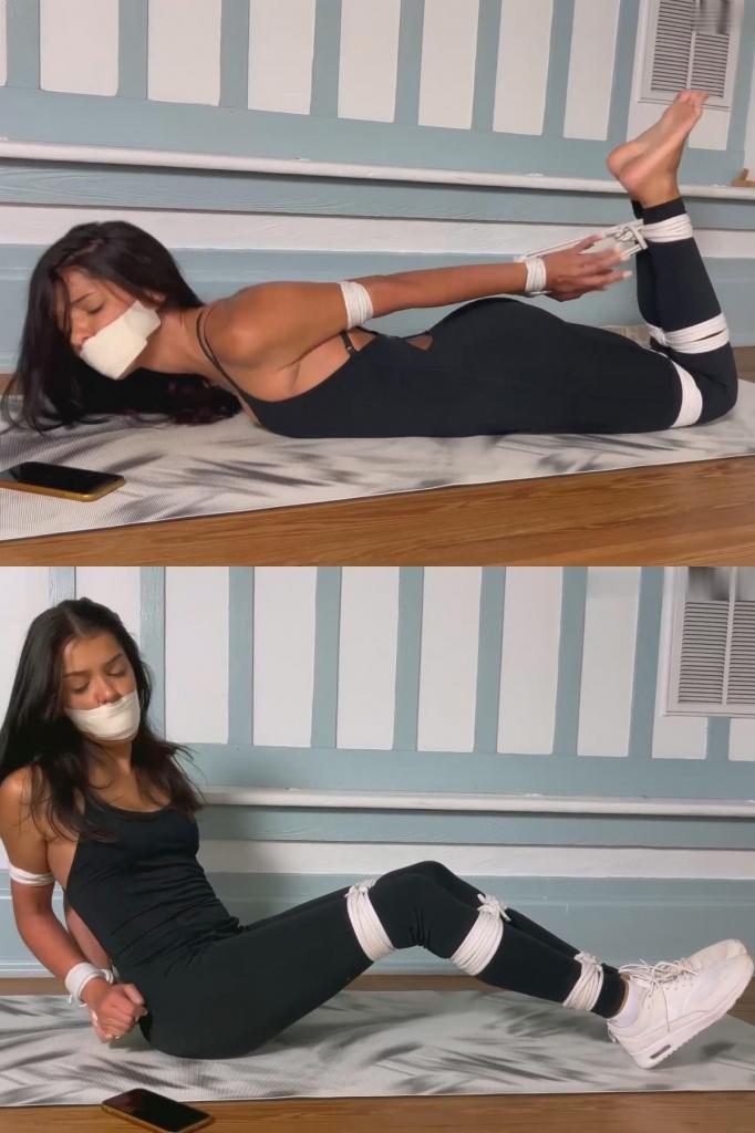 Yoga Babe Ambushed By Instructor Feat Aria Nicole - Tennis Shoes, Microfoam Tape Gag, Gagged Women,  Yoga Babe Ambushed By Instructor Feat Aria Nicole - Tennis Shoes, Microfoam Tape Gag, Gagged Women, Struggling, DID, Hogtie, Rope Bondage, Phone Struggle, Barefoot, Foot Fetish艾莉娅受邀参加一个私人瑜伽课程，她兴致勃勃地前来学习！然而，当她开始伸展身体时，教练却靠得太近了。教练突然袭击了艾莉娅，并将她捆绑起来。艾莉娅的手腕、脚踝、膝盖和手臂都被绑住，她挣扎着想要挣脱束缚。她的手臂因为用力过猛而变得通红，她拼命地摸向自己的包，因为她知道手机就在包里！她试图从包里拿出手机，但由于手腕上的束缚太紧，她费了好大劲才拿到。她终于把手机从包里掏出来，开始打字，但没过多久，她再次遭到袭击！现在，艾莉娅被粗暴地捆绑成猪蹄状，但她仍然试图打电话求救！她的嘴被一个精致的微泡沫口塞堵住，她只能用鼻子在手机上打字，祈祷自己不要打错字！Aria was invited to a private yoga course, and has showed up eager to learn! Except when she begins stretching, the instructor get's way too close. The instructor ambushes Aria and ties her up. With bound wrists, ankles, knees, and arms Aria squirms and fights to get out of her binds. Her arms turn red as she struggles to her bag, where she knows her phone is! She attempts to grab her phone out of her bag, but struggles because of how tight her wrist restraints are. She wiggles her phone out of the bag, and begins typing, but it's not long before she's ambushed once more! Now in a rough hogtie, Aria still tries to call somebody for help! Gagged with a neat microfoam gag, she types on her phone w her nose, praying she doesn't make any typos!