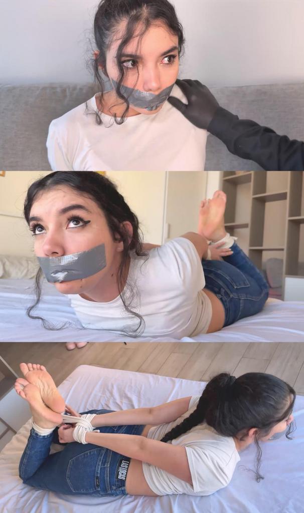 Gagged to STOP the World Cup?! Footballer’s Girlfriend Addy Gets TIGHTLY Tape SEALED!- tapegagged, h Gagged to STOP the World Cup?! Footballer’s Girlfriend Addy Gets TIGHTLY Tape SEALED!- tapegagged, hogtied, lip imprint, struggling 可爱的艾迪在电话里气呼呼地坚持说，不管别人怎么说，她的足球运动员男友都要参加决赛。她做梦也没想到，就在同一天下午，她会被绑在床上，嘴巴也被胶带封住……这一切竟然是为了阻止世界杯决赛？！<br><br>可爱的艾迪坐在客厅的沙发上，一脸愤愤不平地打电话。“我的男友哈维尔一定会赢决赛，不管你喜不喜欢！”她坚定地说。电话那头的人试图说服她劝他别上场，因为这关系到很多钱。挂断电话后，她大声说，这已经是他们第六次打电话了，她很担心，打算警告一下男友。<br><br>艾迪正在和男友通电话，男友安慰她说不用担心这些奇怪的电话。但突然……嗯！艾迪美丽的嘴巴被一只戴着黑色乳胶手套的手紧紧地捂住了！惊喜吧，艾迪！看来你家有客人了！<br><br>艾迪顽皮地挣扎着，发出闷闷的呻吟。蒙面男子在她耳边低语，说他只是来取东西，很快就会离开。他轻轻地把她脸朝下放在沙发上，开始用绳子紧紧地绑住她的手腕。艾迪扭动着身体，一边挣扎一边发出细小的呻吟，问道：“你是谁？”<br><br>他继续用绳子在她手腕上缠绕了好几圈，把绳结系得紧紧的，然后又绑到她的脚踝，同样牢牢地绑住。艾迪一直挣扎着，直到他绑完。他小心翼翼地把她抱起来，让她坐起来，再次捂住她的嘴让她安静下来，但她可爱的闷哼声仍然清晰可闻。然后，他拿来一条灰色的胶带，封住了她柔软的嘴唇，反复抚平，确保胶带紧实平整。艾迪无奈地看着他，翻了个白眼，装出一副不耐烦的样子。蒙面人坦白说，他其实需要她去劝哈维尔不要参加决赛，因为决赛涉及一大笔钱。他还告诉她，她就是他来“收走”的“物品”！嗯哼！艾迪惊讶地瞪大了眼睛。她皱着眉头从沙发上站起来，可爱地蹦蹦跳跳地朝门口跑去，想逃走。<br><br>蒙面人追上了她，轻而易举地把她扛到肩上，一边拍着她的屁股一边把她扛到卧室。他把她放在床上，让她无法逃脱。艾迪不停地挣扎和呻吟。他提出要打电话给她的男朋友去劝说他。艾迪一脸恼火，嘴里塞着东西，试图抗议。蒙面男子拨通了电话，轻轻撕开胶带，让她能开口说话。“亲爱的！他们把我绑起来了！他们命令你明天不许玩游戏……嗯……！”话音未落，她的嘴又被入侵者用胶带封住了！<br><br>他决定确保她真的无处可逃：他又拿了一根绳子，把她捆成猪蹄状，紧紧地绑了起来。艾迪不停地挣扎呻吟，但嘴上的胶带让她什么也发不出来。他打好结，又拍了拍她的屁股，然后把她留在床上，紧紧地捆绑着，嘴也被堵住了，挣扎着，却动弹不得，也无法逃脱。<br><br>包含幕后花絮和解开嘴的片段。When sweet Addy was angrily talking on the phone, insisting that her football player boyfriend was going to play in the final match no matter what anyone said, she never imagined that same afternoon she would end up tightly hogtied on the bed with her mouth taped shut… all this to stop the World Cup final?!<br><br>The adorable Addy is sitting on the couch in her living room, talking on the phone with an indignant look on her face. “My boyfriend Javier is going to win the final, whether you like it or not!” she says firmly, while the person on the other end tries to convince her to tell him not to play because there’s a lot of money at stake. After hanging up, she says out loud that this is already the sixth time they’ve called her and that she’s going to warn her boyfriend because she’s worried.<br><br>Addy is on the phone with her boyfriend, who tells her not to worry about the strange calls. But suddenly... Mmmmpppph! Addy's beautiful mouth is firmly covered by a black latex-gloved hand! Surprise, Addy! Looks like you have company at home!<br><br>Addy struggles in a playful way, letting out muffled moans. The masked man whispers in her ear that he’s only there to pick something up and that he’ll leave soon. He gently lays her face down on the couch and starts tying her wrists tightly with rope. Addy shifts and struggles between little moans, asking “Who are you?”<br><br>He keeps wrapping several turns of rope around her wrists, tightening the knot nicely, and then moves down to her ankles, binding them just as securely. Addy continues to struggle until he finishes. He lifts her carefully, sits her up, and covers her mouth again to keep her quiet, though her adorable muffled sounds can still be heard. Then he takes a strip of gray duct tape and gagged her soft lips with it, smoothing it down several times to make sure it’s tight and wrinkle-free. Addy looks at him with exasperation, rolling her eyes and struggling with mock annoyance.The masked man confesses that he actually needs her to convince Javier not to play in the final because there’s a lot of money involved. He tells her that she is the “object” he came to collect! Mmmmphh! Addy’s eyes widen in surprise. With a frown, she stands up from the couch and starts hopping adorably toward the door, trying to get away.<br><br>The masked man catches up to her, lifts her smoothly over his shoulder, and gives her a few pats on the butt as he carries her to the bedroom. He lays her down on the bed so she can’t escape. Addy keeps struggling and moaning. He offers to call her boyfriend to convince him. Addy, looking annoyed, tries to protest through the gag. The masked man dials the number, peels the tape back just enough for her to speak.. “Honey! They've got me tied up! They're demanding you don't play the game tomorr…mmmmppphhh!!!” Suddenly, her lips are once again sealed with tape by the intruder!<br><br>He decides to make sure she really can’t go anywhere: he takes another rope and ties her in a tight hogtied position. Addy keeps struggling and moaning, but everything stays muffled by the tape sealing her mouth. He finishes the knot, gives her a couple more pats on the butt, and leaves her there on the bed, tightly bound and gagged, struggling and unable to move or escape.<br><br>Includes behind-the-scenes footage and the ungagging sequence.