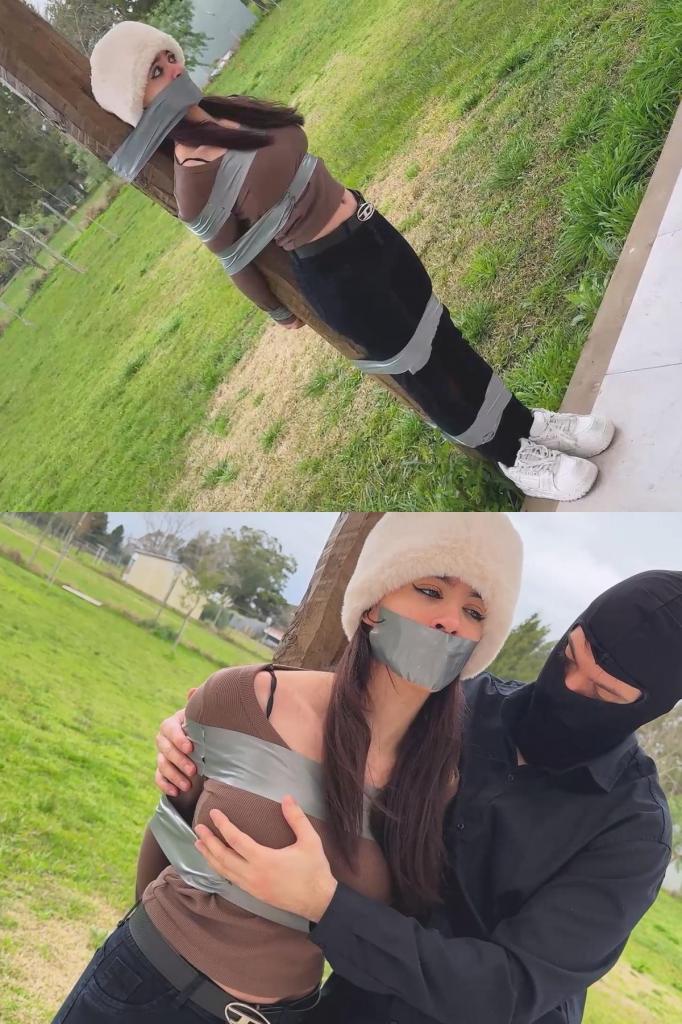 Taped to a Post?! Nani Gets CAUGHT and FULLY SEALED in the Open Field! - tapegagged, outdoor, tape b Taped to a Post?! Nani Gets CAUGHT and FULLY SEALED in the Open Field! - tapegagged, outdoor, tape bondage, struggling 可爱的娜妮在乡间别墅里悠闲地享受着宁静，做梦也没想到会在田野里被一个闯入者追赶、抓获，最后被紧紧地绑在一根木桩上，嘴巴也被严严实实地封住了！<br><br>可爱甜美的娜妮在乡间别墅里惬意地享受着乡村的宁静……突然，一个蒙面男子出现，开始追赶她！快跑，漂亮的娜妮，拼命地跑！娜妮拼命地跑啊跑，突然……嗯！他从后面一把抓住她，用手捂住了她的嘴。<br><br>甜美的娜妮挣扎着，发出呻吟，但他径直把她拖到一根木桩旁，开始用灰色胶带紧紧地缠绕她。她的双手也被紧紧地绑在木桩后面。“好紧啊！”娜妮惊叫道，因为她的双腿也被紧紧地绑在了木桩上。更多的胶带缠绕在她的膝盖上……缠绕在她丰满的胸部上……最终，她被牢牢地绑在了木桩上！<br><br>蒙面男子的手再次捂住了她的嘴唇，一边说着“闭嘴”，一边用一条灰色胶带紧紧地贴在娜妮的嘴唇上，将她漂亮的嘴巴严严实实地封住了。他用手抚平胶带，并把它按得更紧。现在，只能听到她发出可爱的“嗯嗯嗯！”的挣扎声，徒劳无功。“喜欢户外活动吗，娜妮？”<br><br>娜妮可爱地挣扎着，蒙面男子轻轻地抚摸着她漂亮的胸部。她回应着闷哼声，徒劳地挣扎着，试图摆脱紧紧地贴在嘴唇和身上的胶带。<br><br>过了一会儿，蒙面男子撕掉了她嘴上的胶带。娜妮满怀希望地睁开眼睛，惊讶不已……但是，不，漂亮的娜妮！还有更多的胶带等着你！现在，她的嘴巴被紧紧地贴在了木柱上。一圈又一圈，一层又一层，直到娜妮完全被粘在了柱子上。她的嘴巴从下巴一直到漂亮的鼻子下方都被胶带紧紧地封住了。她连头都动不了。双眼睁得大大的，只能发出“嗯嗯嗯！嗯嗯嗯！”的声音，最终完全动弹不得。手脚都被缠住，躯干固定住，嘴巴也被封住……可爱的娜妮被做成了一个木头上的胶带雕像！<br><br>可怜的娜妮能挣脱这束缚吗？还是她会整个下午都困在那根柱子上，在空旷的田野里挣扎一整天？快来观看“沉默的可爱”完整版视频，一探究竟吧！<br><br>视频包含幕后花絮和解封片段 When the adorable Nani was peacefully enjoying her country house, she never imagined she would be chased by an intruder in the field, captured, and end up tightly taped against a wooden post with her mouth hermetically sealed!<br><br>The adorable and sweet Nani is happy at her country house, soaking up the quiet of the countryside… until suddenly a masked man appears and starts chasing her! Run, pretty Nani, run with all your might! Nani runs and runs, until suddenly… Mmmhhh! He grabs her firmly from behind and covers her mouth with his hand.<br><br>Sweet Nani struggles and moans, but he takes her straight to a wooden post and begins wrapping her tightly in gray tape. Her hands are tightly taped behind the post. “It’s tight!” Nani exclaims in surprise as her legs are firmly wrapped against the post. More tight tape over her knees… under and over her big breasts… leaving her firmly bound to the wooden post!<br><br>Her lips are covered once more by the masked man’s hand as he says “Shut your mouth” before applying a tight strip of gray tape over Nani’s lips, hermetically sealing her pretty mouth. He runs his hand over the mouth tape, smoothing it and pressing it even tighter. Now only adorable Mmmhhh! Mmmhhh! can be heard as she tries to struggle without success. Enjoying the outdoors, Nani?<br><br>While Nani struggles adorably, the masked man gently touches her pretty breasts. She answers with muffled moans and useless struggling against the tight tape on her lips and body.<br><br>After a while, the masked man peels the tape from her mouth. Nani opens her eyes with hope, surprised… but no, pretty Nani! There’s more tape for you! Now her mouth is wrapped right against the wooden post. Turn after turn, layer after layer, until Nani is completely stuck to the post. Her mouth is tightly sealed with tape from the base of her chin to just under her pretty nose. She can’t even move her head. Her eyes stay wide open and she can only manage Mmmhhh! Mmmhhh! as she ends up completely immobile. Hands and legs wrapped, torso fixed in place, mouth sealed… adorable Nani has been turned into a tape statue on wood!<br><br>Will poor Nani manage to escape this tight situation? Or will she stay stuck to that post all afternoon, struggling the whole day out in the open field? Find out in the full video from Silenced Cuties!<br><br>Includes behind-the-scenes footage and the ungagging sequence.