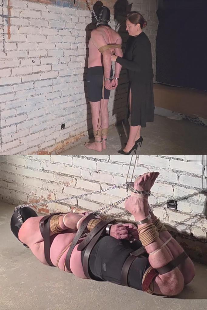 No more running: Hooded, Gagged &amp; Brutal Hogtied in Her Basement 她跟踪他已久。他习惯独自沿着那条僻静的小路奔跑，这成了他日后残酷的玩笑。不久前，他还能自由奔跑，感受着迎面而来的风……如今，他却只穿着一条短跑裤，半裸着身子，鼻子紧贴着冰冷的砖墙。<br><br>一条沉重的铁链从钢制项圈垂到天花板。他的手腕和脚踝已被牢牢地铐在结实的钢制手铐里。头上戴着一个紧紧的黑色感官剥夺头盔。嘴里塞着一个用皮带网固定的大球形口塞。他再也无法奔跑。<br><br>她就在他身边。他看不见她，却能感受到她每一次的触碰，以及她轻柔而满足的低语。女主人缓慢而有条不紊地剥夺了他所有行动的能力。首先，她熟练地将绳索紧紧地套在他脚踝、手腕、手肘和大腿上的钢制手铐上。然后是一堆厚厚的皮带：缠绕在他的躯干上，肘部上下，腰间。他的双臂被紧紧地压在背后。另一条宽皮带将他的双腿勒得更紧。<br><br>鞭子也派上了用场。他扭动着身体，却再也躲不开鞭子的抽打。在她命令下，他挣扎着跪了下来，然后脸朝下趴在冰冷的地下室水泥地上。脚镣的链子扣在地板上的一个环上；项圈的链子扣在另一个环上。更多的皮带被加上，接着是宽大的塑料扎带，捆住了他的胳膊、腿和脚。他似乎已经被完全束缚住了……但这还不够。<br><br>女主人就在水泥地上把他绑成了一个极其严酷的猪蹄式捆绑。她解开他腿上的扣子，弯曲他的膝盖，用链子把他的腿拉到已经被捆绑的胳膊和躯干上，然后用另一根扎带进一步固定住。最终，他被绑成了一个极其紧绷、残酷的猪蹄式捆绑。另一条链子将他的双脚与口塞顶部的环连接起来，并收紧，使他的头向后仰去。他被口塞堵住嘴，发出低低的呜咽声，口水顺着嘴角流到地板上。<br><br>口塞链子的最后一根绳子向上延伸到天花板的支架上。“跑酷者”现在几乎动弹不得——他无法张开双臂和双腿，甚至无法侧身翻滚。她完全控制了他……并且显然很享受其中的每一秒。<br><br>重度男性束缚，极度限制行动，猪蹄式捆绑，钢制束缚带 绳索 皮带 扎带，球形口塞，感官剥夺，鞭打，女性支配。将一名跑酷者彻底改造为无助的附属品。She had been stalking him for a long time. His habit of running alone along the same secluded route played a cruel joke on him. Just recently he was still free to race forward, feeling the wind on his face… Now he stands half-naked, wearing only his short running shorts, nose pressed against the cold brick wall.<br><br>A heavy chain from the steel collar runs up to the ceiling. His wrists and ankles are already locked in sturdy steel cuffs. On his head — a tight black sensory-deprivation helmet. In his mouth — a large ball gag secured by a web of leather straps. Running is no longer possible.<br><br>She is right beside him. He cannot see her, but he feels every touch and her quiet, satisfied whisper. The Mistress slowly, methodically strips away every possibility of movement. First come the skillfully applied and tightly cinched ropes over the steel cuffs on his ankles, wrists, elbows and thighs. Then a pile of thick leather straps: around his torso, above and below the elbows, around his waist. His arms are pressed tightly against his back. Another wide strap squeezes his legs even more firmly together.<br><br>The whip comes into play. He writhes, but can no longer dodge the blows. On her command he struggles down onto his knees, then lies face-down on the bare cold concrete floor of the basement. The chain from the ankle cuffs is clipped to a floor ring; the collar chain to another. More straps are added, followed by wide plastic cable ties around his arms, legs and feet. It seems he is already completely immobilized… yet it is still not enough for her.<br><br>The Mistress ties him up into a severe hogtie right there on the concrete floor. Unclipping his legs, she bends them at the knees and pulls them up with the chain to his already bound arms and torso, securing everything further with another cable tie. The result is an extremely tight, brutal hogtie. Another chain connects his feet to the ring on the top of the gag and is tightened, arcing his head back. He whimpers quietly into the gag as drool runs onto the floor.<br><br>A final rope from the gag chain runs up to a ceiling bracket. The “runner” can barely move at all now — he cannot open his arms or legs, cannot even roll onto his side. She has taken complete control of him… and is clearly savoring every second of it.<br><br>Hard male bondage, extreme immobilization, hogtie, steel restraints   rope   leather straps   zip ties, ball gag, sensory deprivation, whipping, female domination. The complete transformation of a free runner into helpless property.
