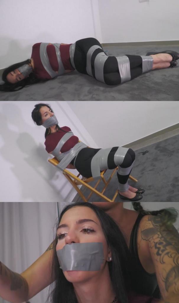 Persefone tied up and gagged by the sexy burglar Margout! (ENGLISH) 珀耳塞福涅（Persefone）刚回到家，正走向自己的房间时，突然一只手捂住了她的嘴。闯入者玛戈（Margout）控制住她并抓住她的双臂，将她带到一个房间，用胶带捆住了她的双手。接着，玛戈用一只袜子塞住珀耳塞福涅的嘴，并缠上好几层胶带将其固定；她在用胶带将珀耳塞福涅捆得严严实实的同时，还出言嘲弄。玛戈暂时离开了，留下珀耳塞福涅在那里挣扎。玛戈回来后，拍打她的屁股，戏弄了她一番。她又拿来一只袜子，在珀耳塞福涅脸上蹭了蹭，随后决定更换塞口物。她撕掉了原先的胶带，但没等珀耳塞福涅把嘴里的袜子吐出来，就又塞进了一只袜子！紧接着，她用大块胶带将珀耳塞福涅的嘴封死。玛戈让珀耳塞福涅坐在椅子上，并将她捆绑在椅子上；她很享受羞辱对方的过程。她再次离开了几分钟，回来时用一块方巾蒙住了珀耳塞福涅的眼睛。最后，她离开了现场，留下珀耳塞福涅被捆绑、封口并蒙住双眼，彻底陷入了无助的境地！ENGLISH AUDIO Persefone just arrived home. She going to her room when suddenly a hand covers her mouth. The burglar Margout handgags her and grabs her arms. She moves her to a room, and there she ties her hands with tape. Then Margout gags Persefone with a sock and several layers of tape. She ties her up really tight with tape while she mocks her. Margout leaves a few minutes and Persefone is left there struggling. When Margout returns, she spanks her ass and plays a little with her. She grabs another sock and rubs it on her face. She decides is time to change the gag. She removes the layers of tape, but before Persefone can spit the sock, she adds the other sock in! Then she gags her with a big tapegag. Margout sits Persefone on the chair and ties her up to the chair. She loves humiliating her. She leaves for a couple minutes. When she returns, she blindfolds Persefone with a bandana. Now she leaves and Persefone is left there tied up and gagged, totally helpless! 